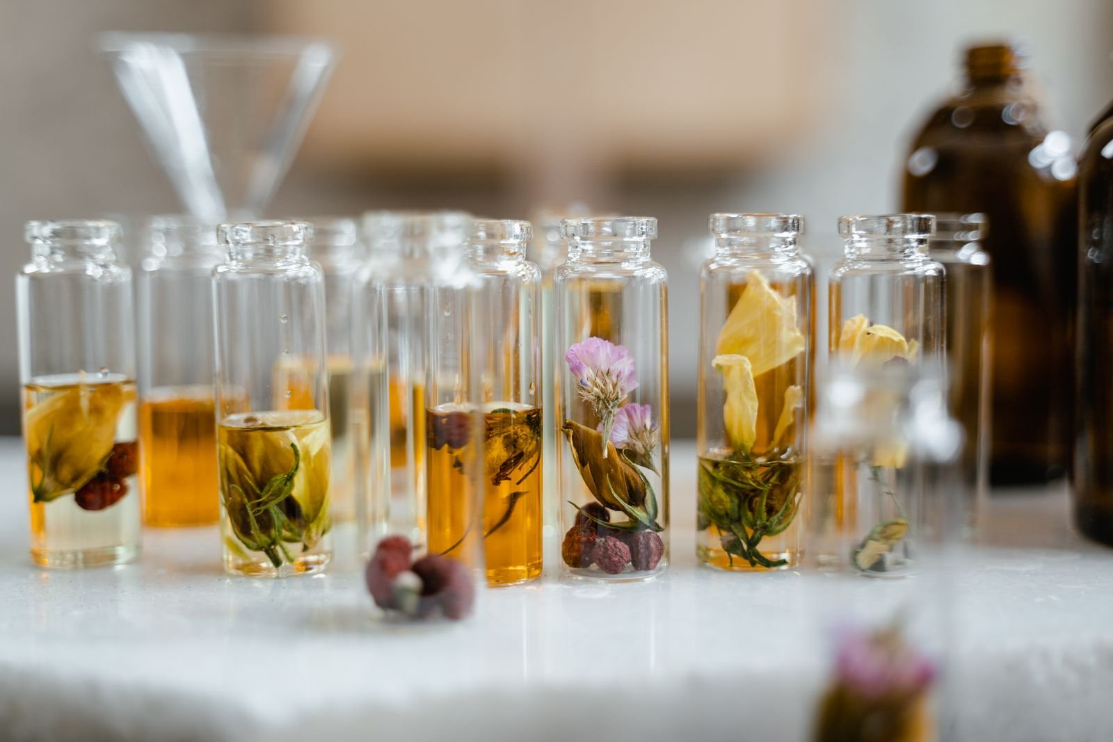 Small glass bottles of botanical infused oils and tinctures with herbs and flowers