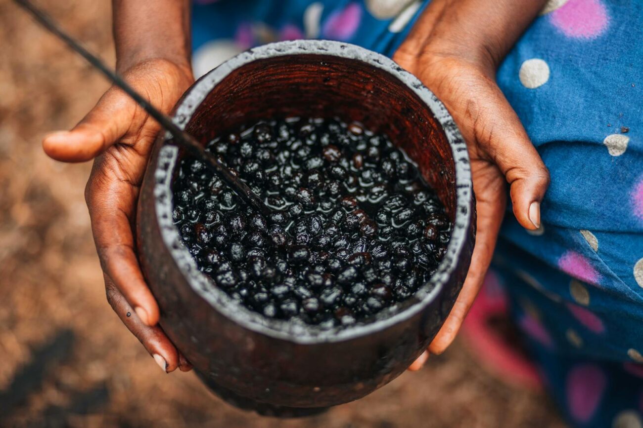 Close-up of a woman holding a bowl of fresh açaí berries, emphasizing natural texture and color.