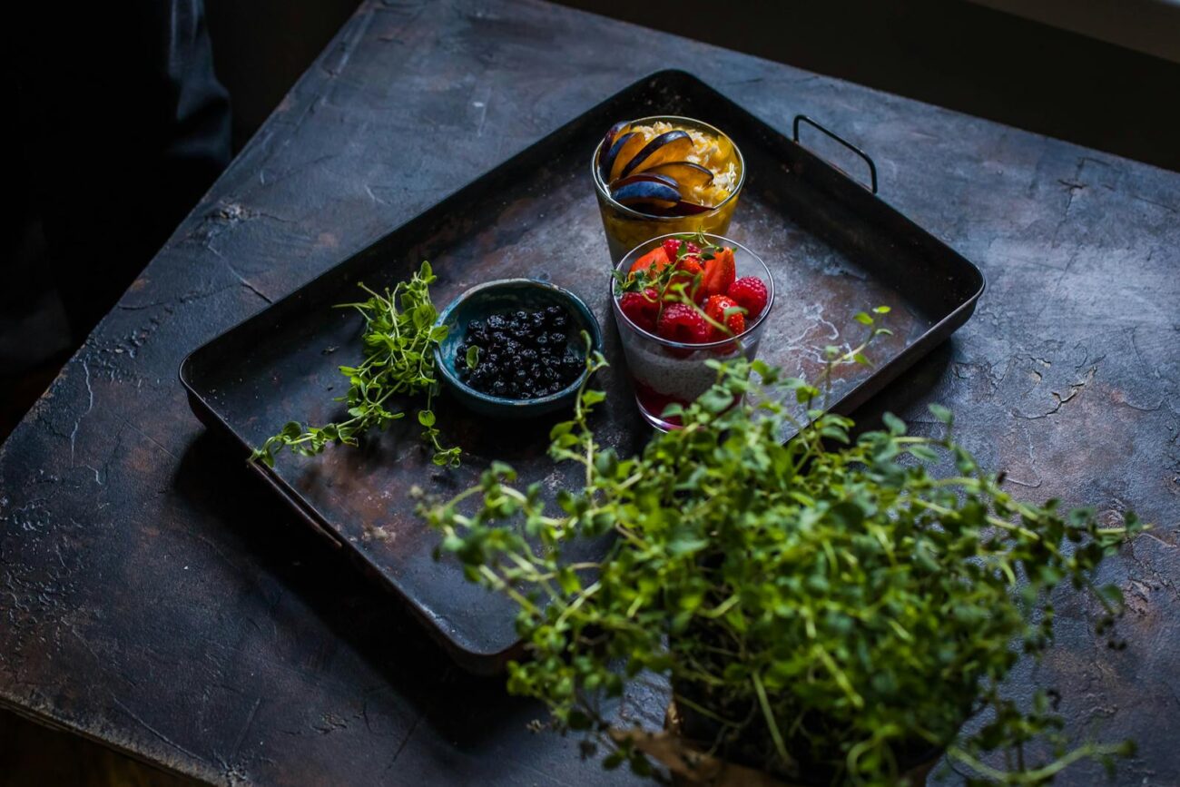 Fresh fruits with herbs on a rustic tray, perfect for healthy eating.