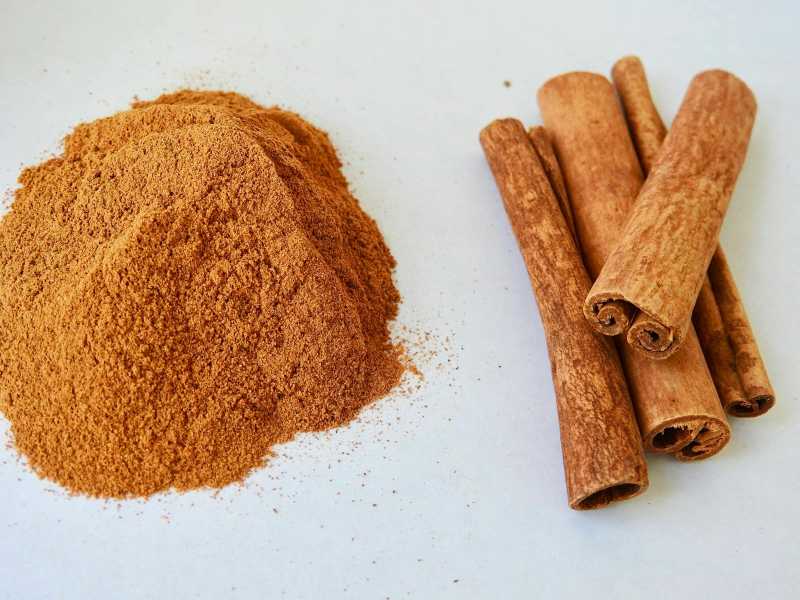 Cinnamomum verum Ceylon cinnamon sticks and powder showing volatile cinnamaldehyde phenylpropanoid secondary metabolite that degrades through oxidation and evaporation in pre-ground powder making freshly ground material preferable for maximum volatile compound preservation.