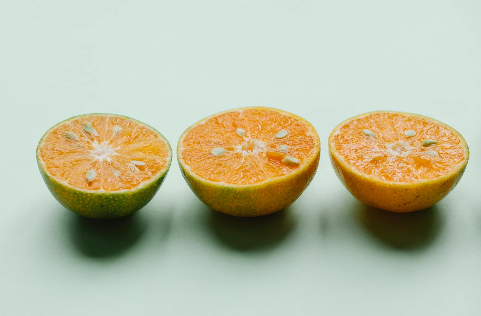 Citrus aurantium bitter orange fruits halved showing orange flesh and seeds where linalool monoterpenoid limonene and synephrine alkaloid compounds accumulate in peel and flower tissue of Citrus aurantium subsp amara used for neroli essential oil extraction with documented GABA-A receptor modulating and adrenergic activity