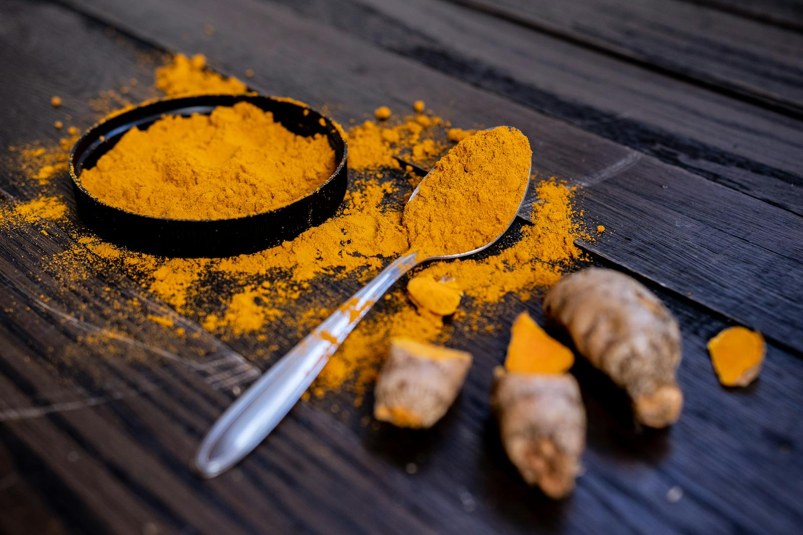 Curcuma longa turmeric powder showing characteristic deep yellow orange colour from curcuminoid secondary metabolites produced through phenylpropanoid pathway as antimicrobial rhizome defence chemistry