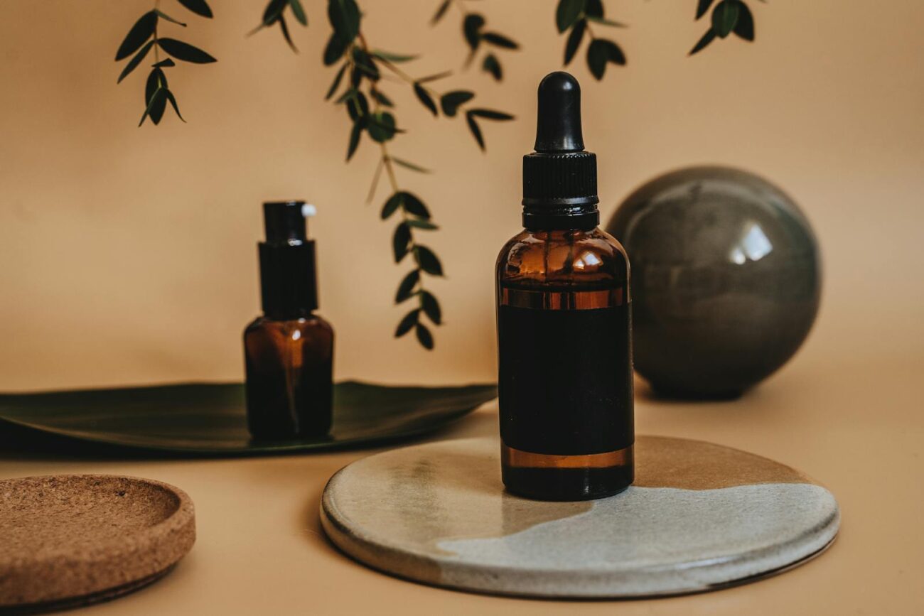 Amber essential oil dropper and spray bottles with eucalyptus leaves showing concentrated plant volatile compound extracts used for aromatherapy and natural pest management applications