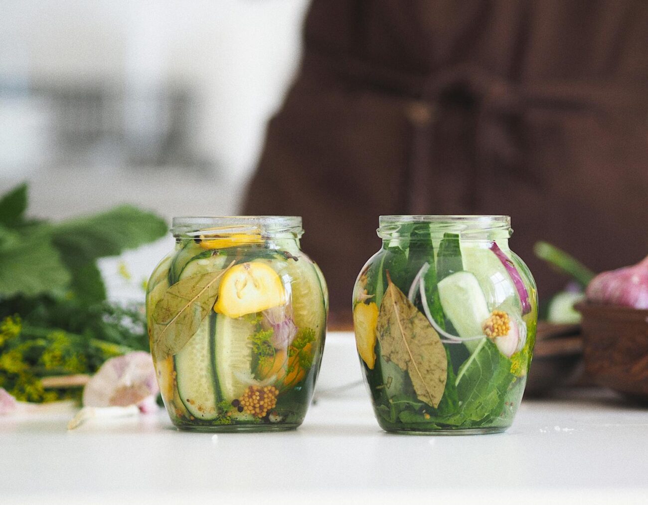 Glass jar containing lacto-fermented herbs in salt brine showing plant secondary metabolite transformation through Lactobacillus bacterial fermentation process converting organosulfur and phenylpropanoid compounds to more bioavailable forms