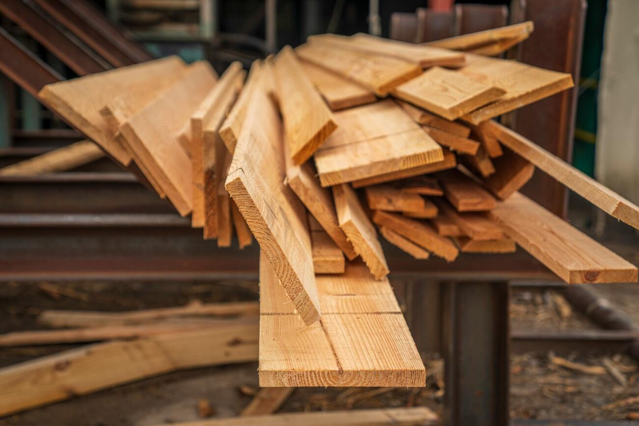 Stacked natural timber planks at a lumber yard showing wood grain used in eco-friendly construction