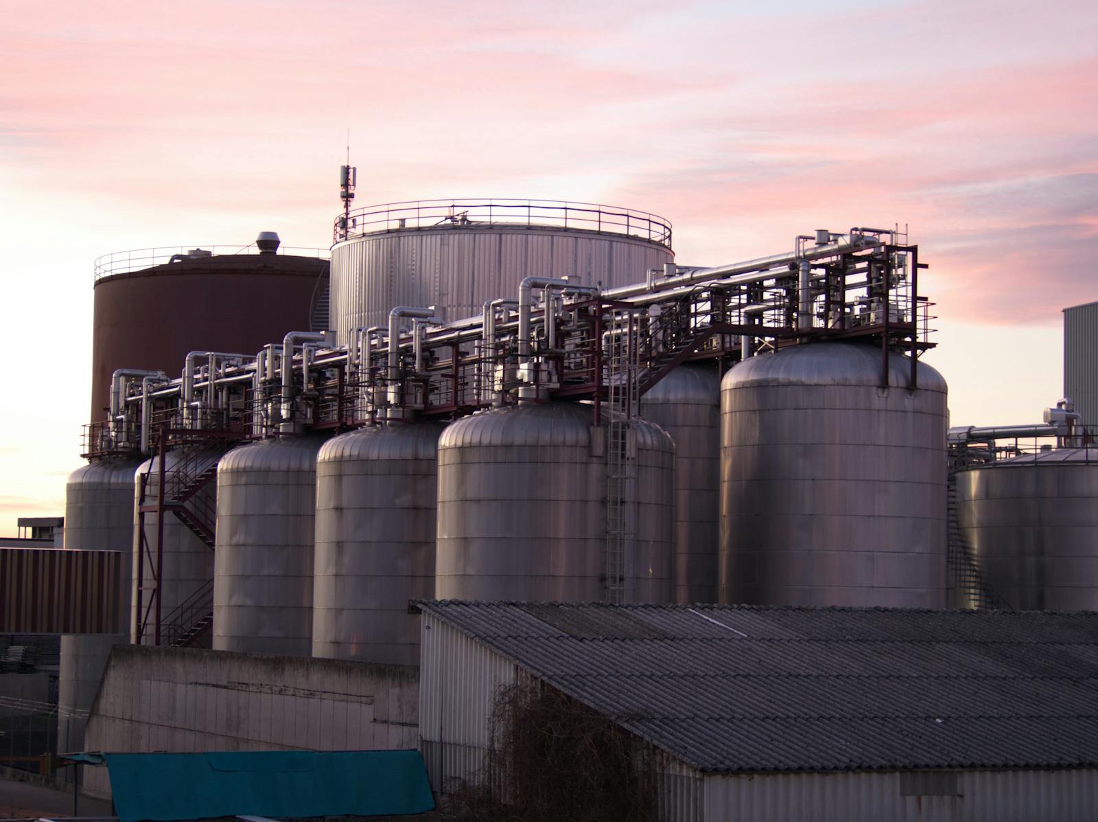 Large industrial anaerobic digestion tanks with interconnecting pipework showing commercial scale biogas production from organic waste