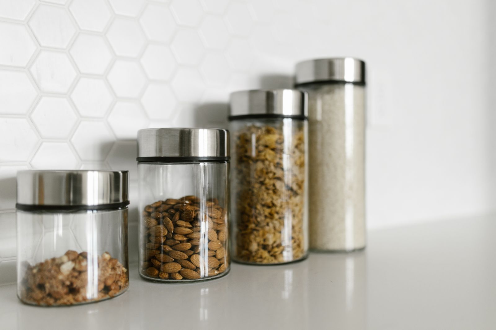 Glass jars with stainless steel lids on a kitchen counter showing chemical leaching free food storage alternatives to plastic containers