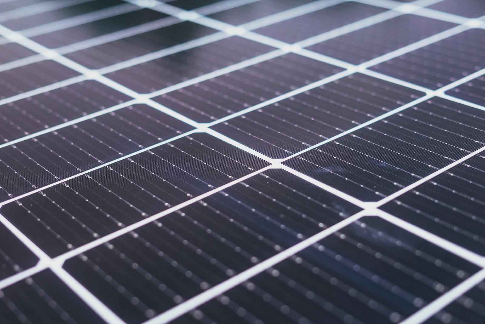 Close-up of monocrystalline silicon solar panel cells showing conductor lines and uniform dark crystal structure