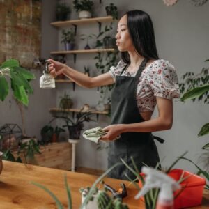 Woman spraying houseplants as part of routine pest care